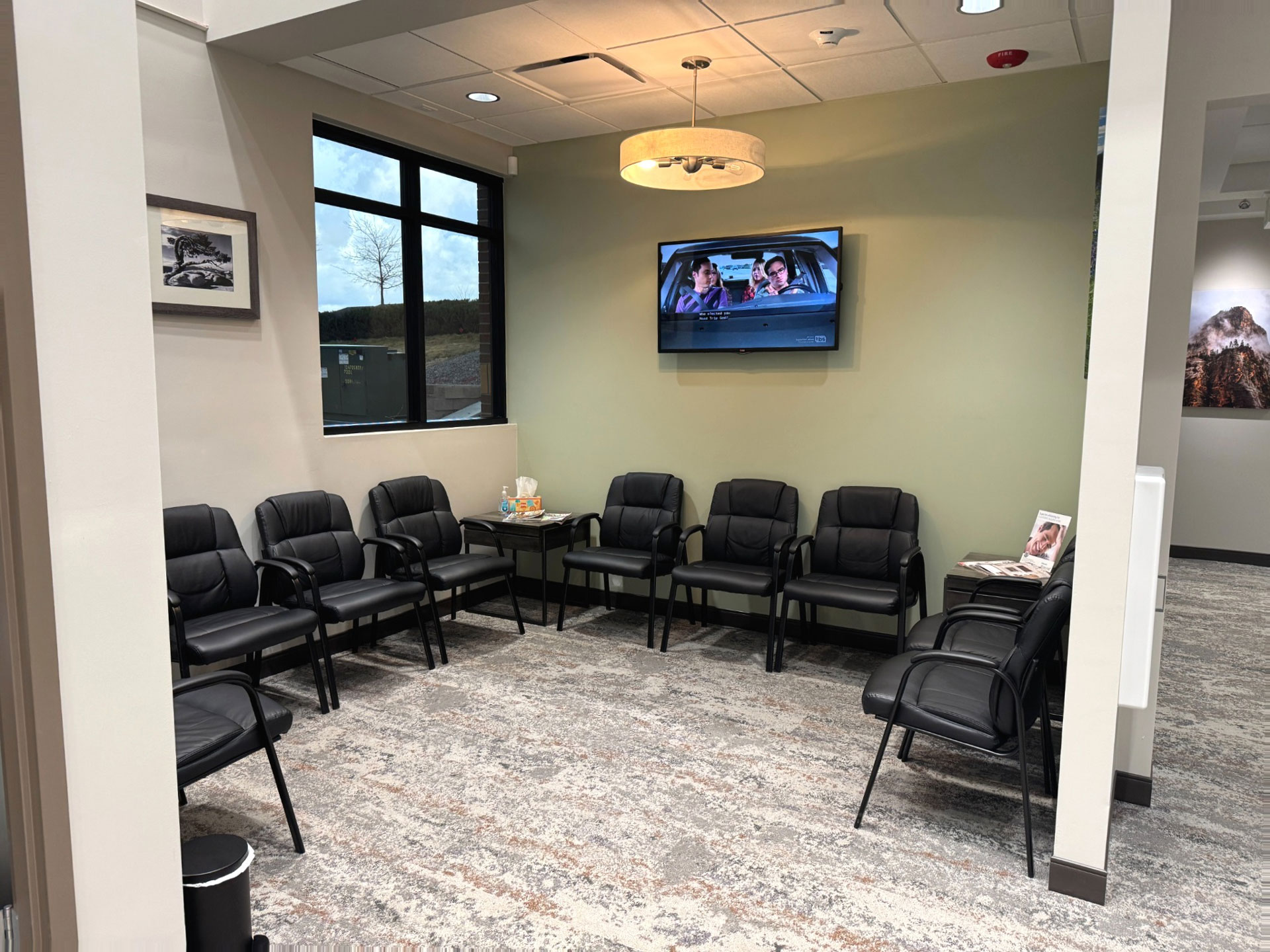 Waiting area with black chairs and TV at Prairie Hawk Dental in Castle Rock, CO