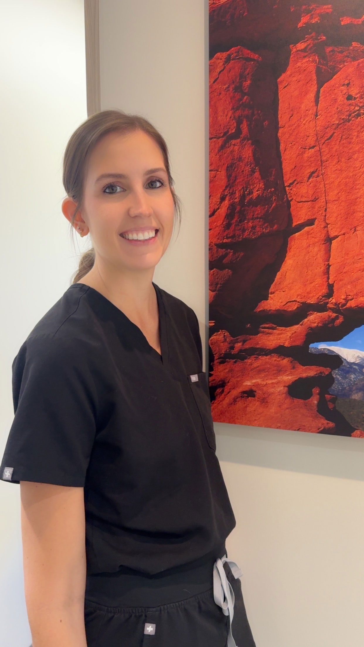 Smiling dental professional in black scrubs at Prairie Hawk Dental in Castle Rock, CO